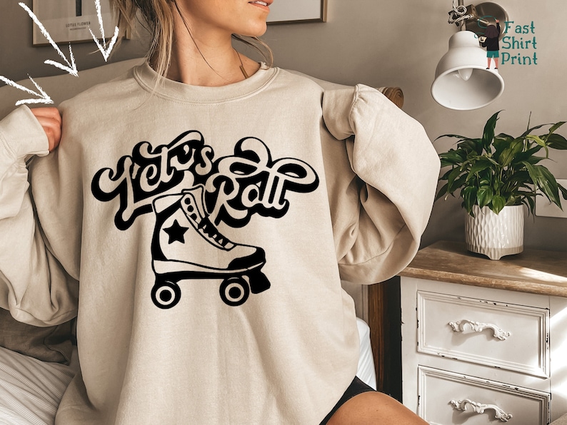 May include: A beige sweatshirt with a black graphic of a roller skate and the text "Let's Roll" in a retro font.