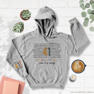 May include: A grey hooded sweatshirt with a Bible verse printed on the front. The verse is in a colourful font and says "Your 41st is coming".