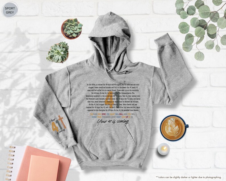 May include: A grey hooded sweatshirt with a Bible verse printed on the front. The verse is in a colourful font and says "Your 41st is coming".