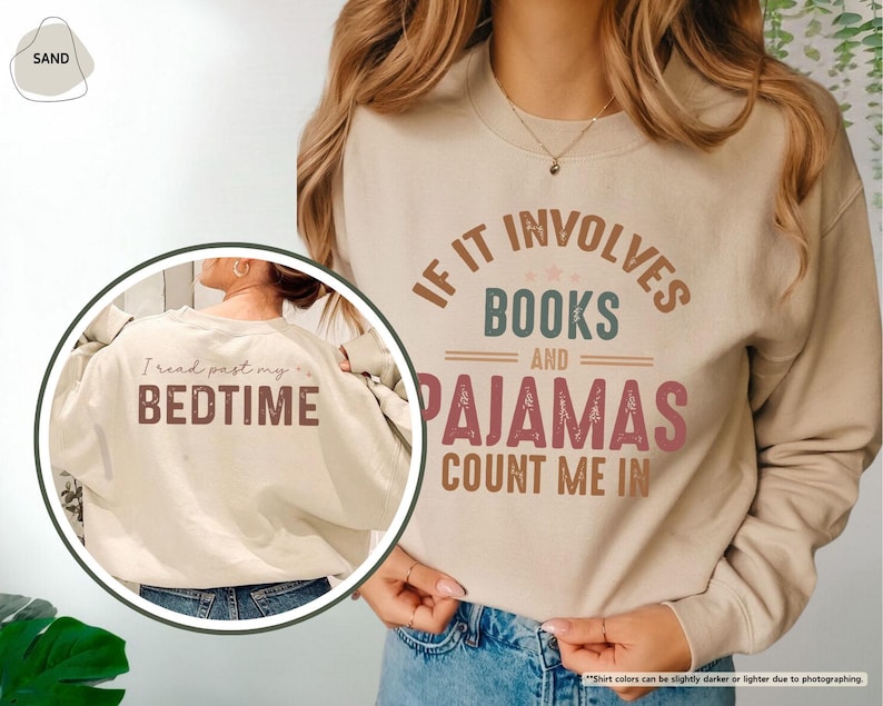 Puede incluir: Una sudadera beige con el texto "IF IT INVOLVES BOOKS AND PAJAMAS COUNT ME IN" impreso en la parte delantera. La parte posterior de la sudadera tiene el texto "I read past my BEDTIME" impreso en ella.