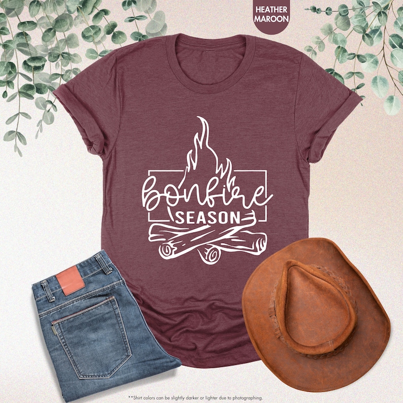 a t - shirt that says bonfire season next to a cowboy hat
