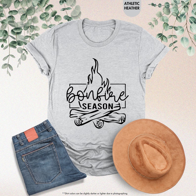 a t - shirt that says bonfire season next to a hat and jeans