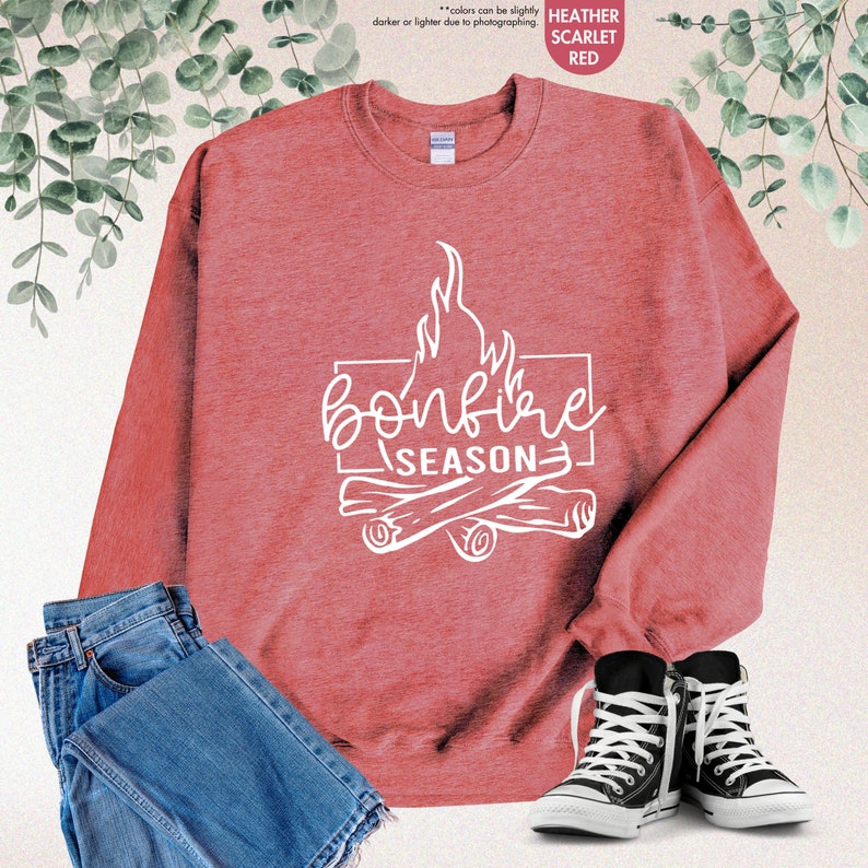 a red sweatshirt that says bonfire season next to a pair of jeans