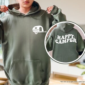 a woman wearing a green happy camper hoodie