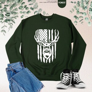 a green sweatshirt with an american flag and a deer's head