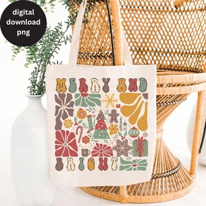 Op de afbeelding: Een witte canvas draagtas met een kerstontwerp. Het ontwerp bevat de woorden "Merry and Bright" in een retro lettertype, omringd door feestelijke elementen zoals sneeuwvlokken, ornamenten, snoepstokken en een peperkoekman.