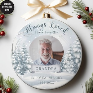 Może przedstawiać: Biała, okrągła ozdoba choinkowa z zimową sceną przedstawiającą zasneżony las i ramkę na zdjęcie. Tekst "Always Loved Never Forgotten" znajduje się na górze ozdoby. Tekst "Grandpa" znajduje się na banerze pod ramką na zdjęcie. Tekst "In Loving Memory 1956-20XX" znajduje się na dole ozdoby.