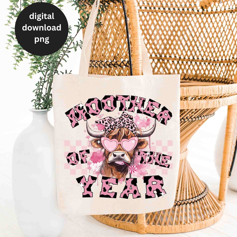 May include: A white tote bag with a pink and black cow graphic and the text "Moother of the Year".