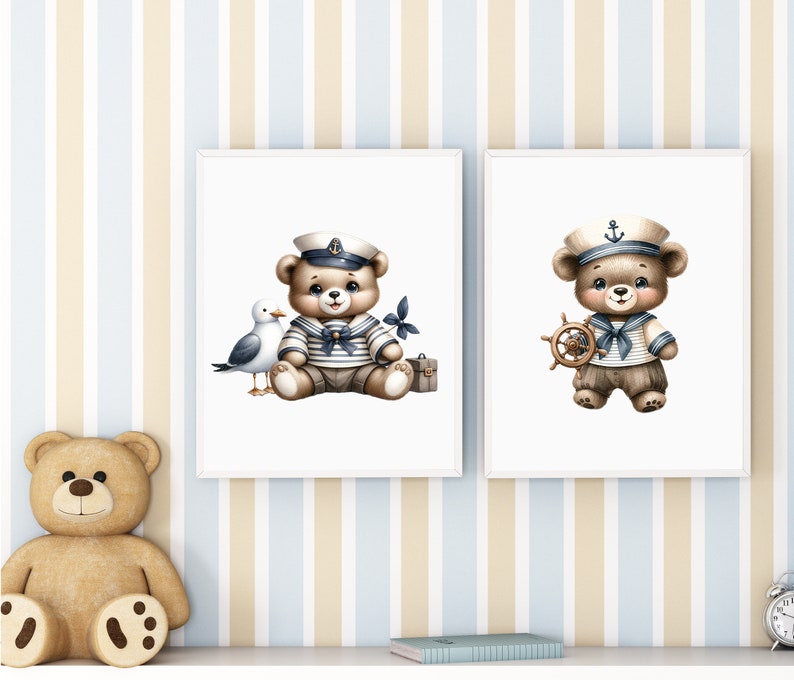May include: Two framed prints featuring illustrations of teddy bears dressed as sailors. The bear on the left is holding a seagull and a suitcase. The bear on the right is holding a ship's wheel. Both bears are wearing blue and white striped sailor shirts and hats.