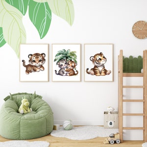 May include: Three framed prints featuring cute cartoon tiger cubs. The first print shows a tiger cub sitting with its paws crossed. The second print shows two tiger cubs hugging under a palm tree. The third print shows a tiger cub sitting with its head tilted up.