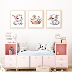 Puede incluir: Tres impresiones enmarcadas de conejos blancos con diademas florales. Los conejos est&aacute;n en diferentes poses, uno est&aacute; sentado, otro est&aacute; en una cesta y el tercero est&aacute; sentado con las patas cruzadas. Las impresiones est&aacute;n en una pared blanca en una guarder&iacute;a.