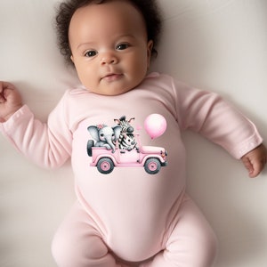 May include: A pink baby onesie with a graphic of a pink jeep with a zebra and elephant riding in it. The jeep has a pink balloon attached to the back.