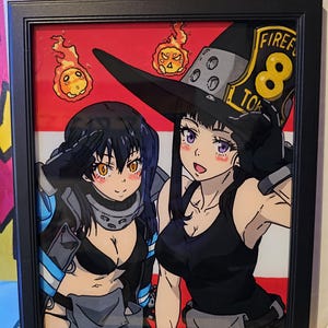 May include: A framed anime-style illustration featuring two characters with dark hair, one wearing a black hat with the text FIRE FORCE 8 TOKYO, set against a red and white background with two small floating orange flame creatures.