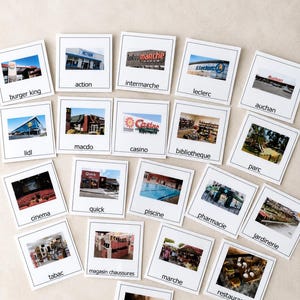 May include: A collection of square white cards featuring various photographs of businesses and public locations, each labeled with text including burger king, action, intermarche, leclerc, auchan, lidl, macdo, casino, bibliotheque, parc, cinema, quick, piscine, pharmacie, jardinerie, tabac, magasin chaussures, marche, restaurant, and coiffeur.
