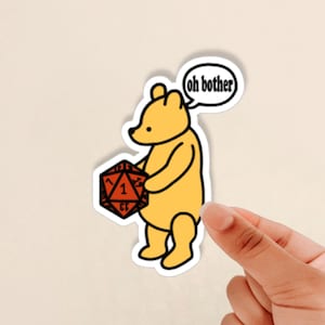 May include: A yellow cartoon bear holding a red 20-sided die with a 1 showing. A speech bubble above the bear says "oh bother".