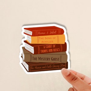 May include: A stack of five books with colorful covers. The titles are "Romeo & Juliet", "The Song of Achilles", "A Court of Thorns and Roses", "The Mystery Guest", and "The Heaven and Earth Grocery Store".