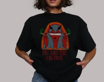 May include: Black t-shirt with a red and orange graphic of a devil woman with green smoke coming from her hands. The text "FIG AND THE CIG FIGS" is printed below the graphic.