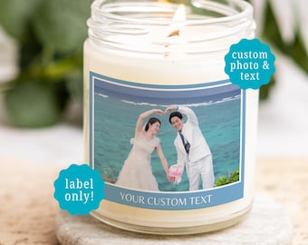 May include: A clear glass jar candle with a white wax fill and a wooden wick. The label features a photograph of a couple in wedding attire forming a heart shape with their arms against a beach background, with the text YOUR CUSTOM TEXT below.