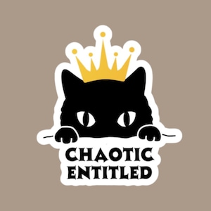 May include: A sticker featuring a black cat wearing a gold crown. The cat's head and paws are visible, with the words "CHAOTIC ENTITLED" in bold, black letters below. The sticker has a white border and is set against a neutral background.