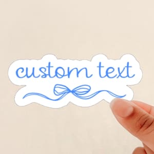 May include: A white sticker with a blue ribbon and the text "custom text" in blue cursive.