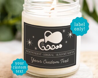 May include: A clear glass jar candle with a lit wick and a black rectangular label. The label features a white Aquarius water pitcher icon, stars, and the text INDEPENDENT ORIGINAL HUMANITARIAN and Your Custom Text. Two blue circular badges read label only! and your custom text.