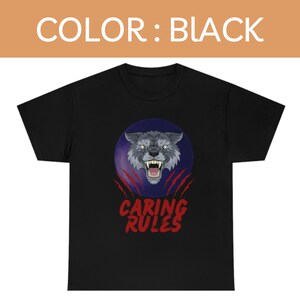May include: Black t-shirt with a graphic of a wolf's face in a circle with red claw marks and the text "Caring Rules" underneath.