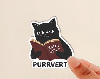 May include: A die-cut sticker featuring a black cat with a white face and pink blush marks, holding an open brown book with the text Extra Spicy printed on the cover. Below the cat, the word PURRVERT is printed in bold black capital letters.