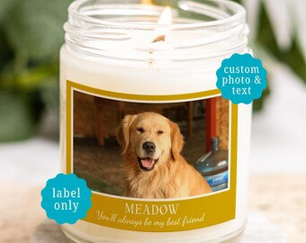 May include: A clear glass jar candle with a white wax fill and a lit wick. The label features a photograph of a golden retriever, the name MEADOW, and the text You'll always be my best friend. Two blue starburst icons display custom photo & text and label only.