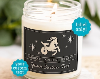 May include: A clear glass candle jar with a lit wick and a black rectangular label. The label features a beige Capricorn sea-goat illustration, star icons, and the text AMBITIOUS PRACTICAL RESILIENT and Your Custom Text. Two teal starbursts read label only! and your custom text.