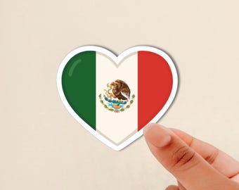May include: A heart-shaped sticker featuring the flag of Mexico with its vertical green, white, and red stripes and the central coat of arms depicting an eagle perched on a cactus devouring a snake, all set against a plain light background.