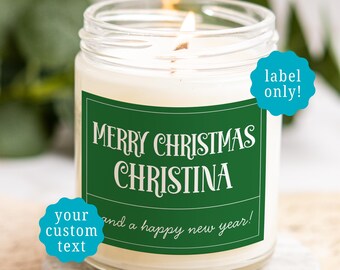 May include: A clear glass candle jar with a white wax fill and a lit wick. The jar features a rectangular green label with white text that reads Merry Christmas Christina and a happy new year. Two blue starburst icons contain the text label only and your custom text.