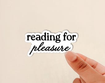 May include: A die-cut sticker with a white background and a black border featuring the text reading for pleasure in a combination of serif and script fonts. The word reading is in a bold serif font, while the word pleasure is in a cursive script.