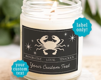 May include: A clear glass jar candle with a lit wick and a black rectangular label. The label features a beige crab illustration, star icons, and the words IMAGINATIVE, LOYAL, TENACIOUS, and Your Custom Text. Two teal circular text overlays read label only! and your custom text.