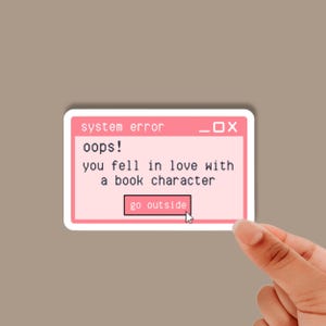 May include: A pink and white computer error message sticker with the text "system error oops! you fell in love with a book character go outside".