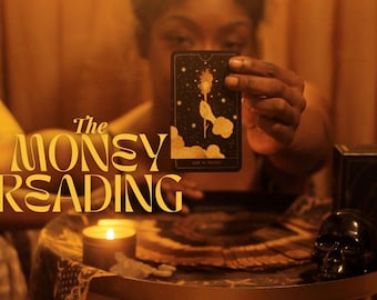May include: A person performs a money reading with tarot cards. The card being held is the Ace of Wands, a black card with gold accents and a depiction of a hand holding a flaming torch. The text "The Money Reading" is in the foreground in a gold font.