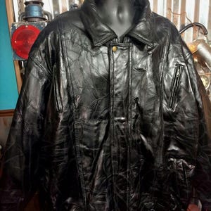 May include: A black leather bomber jacket with a quilted design. The jacket has a zipper closure and a stand-up collar.