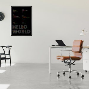 May include: A black and white poster with colorful code and the text "HELLO WORLD" hanging on a white wall in a modern office. A brown leather office chair sits in front of a white desk with a laptop and a lamp.