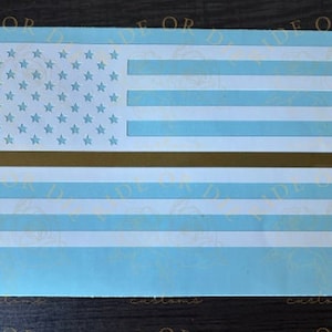 May include: A white and gold thin line American flag decal. The flag has a thin gold line across the middle of the stripes.