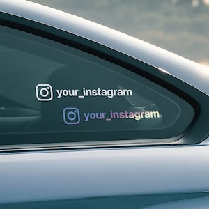 May include: A gray car with a rear window that has two Instagram logos and the text "your_instagram" on it.