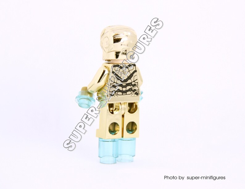 Puede incluir: Minifigura Lego de Iron Man de color dorado con un acabado dorado met&aacute;lico y un dise&ntilde;o negro y plateado en el pecho. La minifigura tiene piernas azules transl&uacute;cidas.