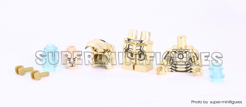 Puede incluir: Piezas de minifigura Lego doradas que incluyen un torso, piernas, cabeza y dos manos. El torso tiene un dise&ntilde;o dorado y negro. La cabeza tiene una cara dorada con un ojo negro y una boca negra. Las piernas son doradas con un dise&ntilde;o negro. Las manos son doradas.
