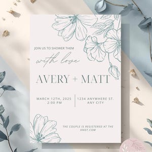 May include: A light beige invitation with floral illustrations in a muted teal color. The text reads "Join us to shower them with love" and announces the names Avery + Matt, the date, time, and location of the event. The couple is registered at the knot.com.