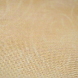 May include: A close-up of a light brown fabric with a subtle woven texture.