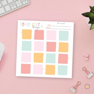 May include: A square to-do list bingo notepad featuring a grid of sixteen colorful squares in shades of yellow, coral, pink, and mint green. The header reads To-Do List Bingo and includes lines for the reward, line, and bingo goals.