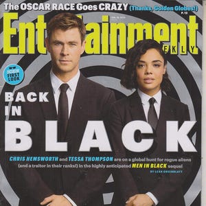 Puede incluir: Portada de la revista Entertainment Weekly con Chris Hemsworth y Tessa Thompson con trajes negros. El titular dice "BACK IN BLACK" con texto sobre la secuela de Men in Black. La portada también incluye el texto "EXCLUSIVE FIRST LOOK".