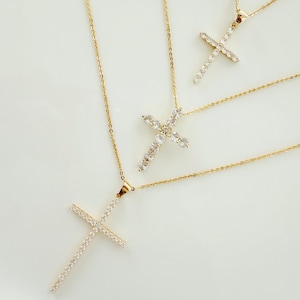 Peut inclure: Trois colliers en or avec des pendentifs en forme de croix sertis de diamants. Les croix sont de tailles différentes et sont superposées.