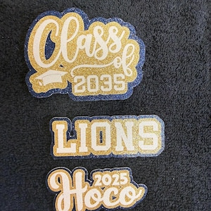 three stickers or patches with text and logos related to graduation or school events.