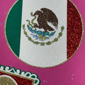 a circular design with a red, white, and green border, and a decorative border around the border. The border is adorned with glitter and has a pattern of leaves and flowers.
