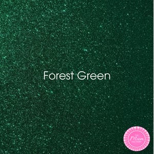 May include: A forest green glitter texture with a dense, sparkling finish. The text "Forest Green" is centered in white, and a circular pink logo with the text "THE MUM FACTORY" is positioned in the bottom right corner of the image.