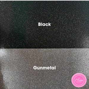 May include: A split-screen display showing two textured glitter surfaces. The top section is black with the text Black, and the bottom section is gunmetal gray with the text Gunmetal. A pink circular logo with the text The Mum Factory is visible.